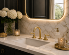 Bathroom vanity with marble countertop, gold faucet, and decorative items.