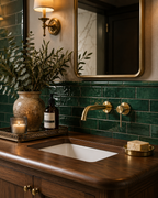 Wall mounted brass faucet in luxury green tile bathroom