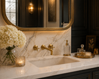 Luxurious bathroom with marble countertop, gold fixtures, and decorative elements.