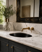 Modern brass faucet with marble vanity and black sink