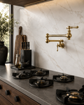 Modern kitchen with gas stove, marble wall, and gold faucet.